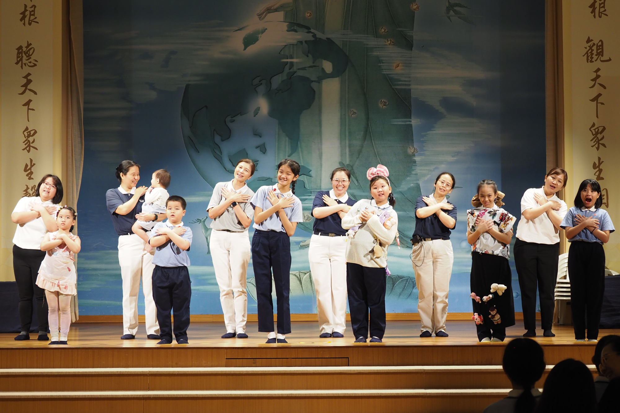 The sign language performance of the song ‘Dedication’ is being presented as the highlight of the event, with children, parents, and team facilitators performing together on stage. (Photo by Tay Zhi Ming) 